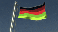 a red black and green flag is flying in the wind