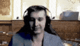 a man wearing headphones is sitting in front of a computer monitor .