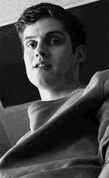 a black and white photo of a young man wearing a grey sweatshirt