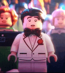 a lego man in a tuxedo and bow tie is standing in a crowd