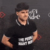 a man is wearing a black shirt that says the people want more