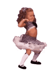 a little girl is dancing on a white background . she is wearing a purple dress and white socks .