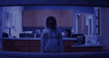 a man wearing a hoodie that says ' converse ' on it stands in front of a counter