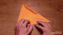 a person is making an orange triangle with the words made in animotica below them