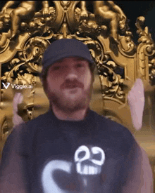 a man wearing a hat and a t-shirt with the number 22 on it is standing in front of a gold statue .