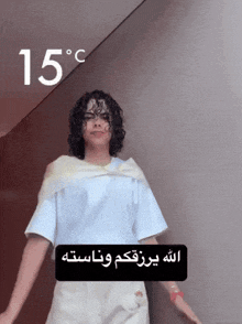 a woman with curly hair is standing in front of a wall with 15 degrees celsius on it