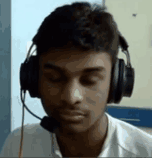 a young man wearing headphones with a microphone attached to his head .