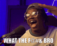 a man wearing glasses and a hat is screaming into a microphone and says what the f @ # & bro .