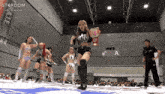 a woman in a stardom shirt is holding a wrestling championship belt