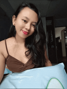 a woman in a brown top is laying on a blue pillow