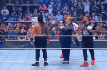 wrestlers in a wrestling ring with the hashtag #wweuniversal championship on the bottom