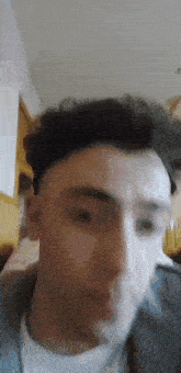 a close up of a man 's face in a room with a blurred background .