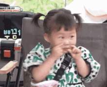 a little girl with pigtails is sitting in a chair with a toolbox in the background that says ' to ' on it