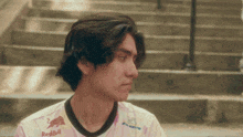 a man wearing a redbull shirt sits on some steps