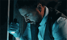 a man with a beard is holding a flashlight in his hand