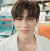 a young man in a white shirt is looking at the camera .