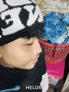 a boy wearing a black and white hat with the word helow on the bottom