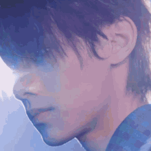 a close up of a young man 's face with a blue shirt on