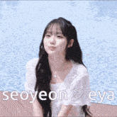 a girl with long hair is smiling in front of a pool with the name seoyeon eya on the bottom