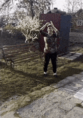 a woman is standing in the grass with a hula hoop in her hand .