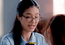 a girl wearing glasses is asking what to another girl