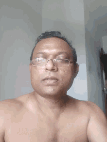 a man without a shirt is wearing glasses