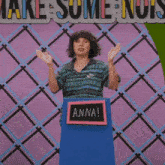 a woman stands at a podium with a sign that says anna on it