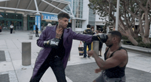 a man wearing everlast boxing gloves is boxing another man