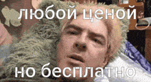 a man is laying on a bed with a green pillow on his head and a caption in russian .