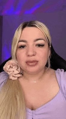 a woman with blonde hair is wearing a purple top and a purple headband .