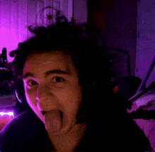a woman sticking her tongue out in a dark room .