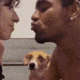 a man and a woman are looking at each other while a dog watches .