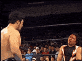 a wrestler with a bloody face is standing in front of a crowd