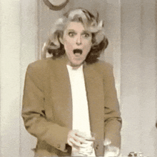 a woman with a surprised look on her face is holding a glass of milk