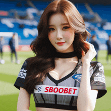 a woman wearing a sboobet shirt is standing on a field