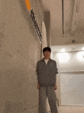 a man is standing in front of a wall that has the word deluxe written on it