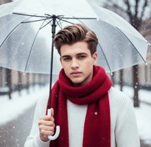 a man wearing a red scarf and a white sweater is holding an umbrella