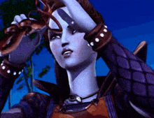 a woman in a purple sweater is holding a snake in her hand