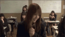 a girl is smiling in a classroom with other students