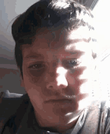 a close up of a man 's face with the sun shining on his face .