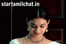 a woman with a red dot on her forehead looks at the camera with the website starttamilchat.in written above her