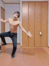 a shirtless man is dancing in a hallway