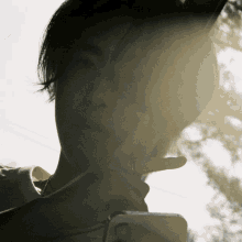 a close up of a person 's face with the sun shining through their hair