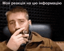 a man with a beard is smoking a cigar while talking on a phone .