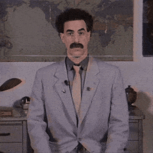 a man in a suit and tie is standing in front of a world map