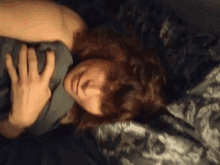 a person is laying on a bed with their hand on their chest