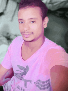 a young man wearing a pink shirt that says ' a & m ' on it