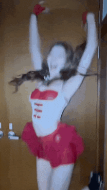 a woman in a red skirt is dancing with her arms in the air