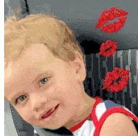 a young boy is sitting in a car seat with red lips coming out of the back seat .