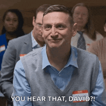 a man wearing a name tag that says david is standing in a line with other people .